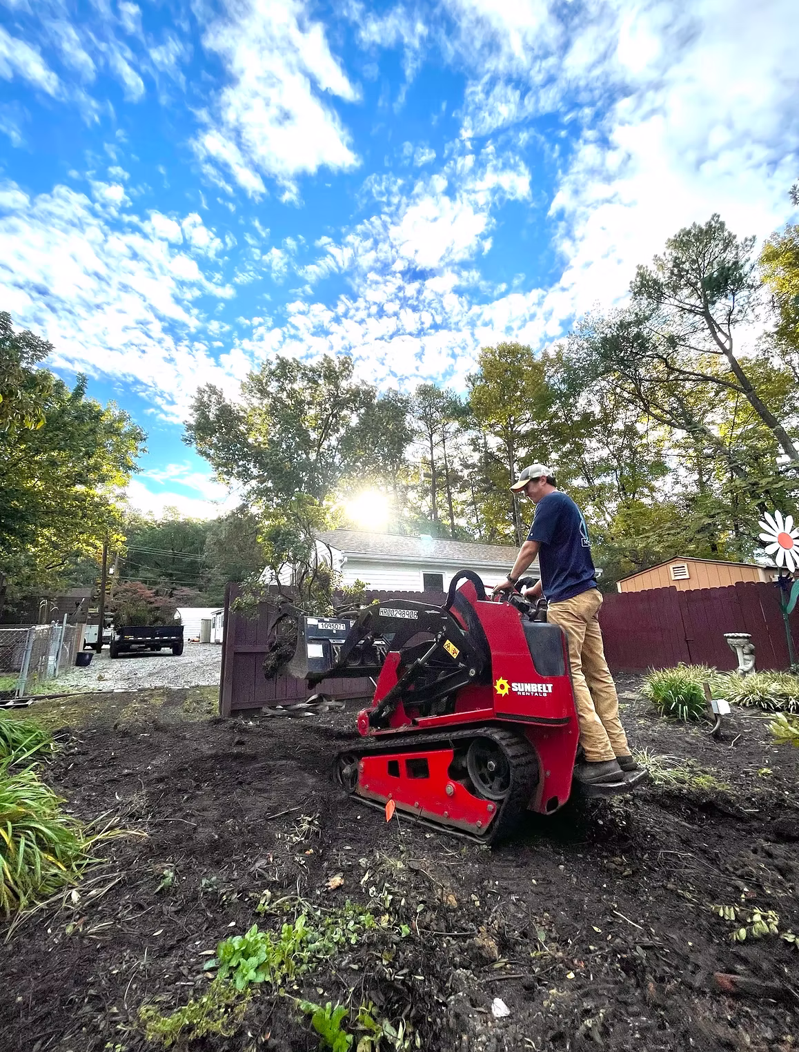 Montgomery Landscape crew member operating a compact track loader during a backyard grading project in Richmond, VA