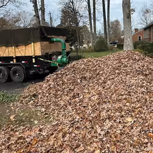 Pile of raked leaves beside the crew's trailer after a cleanup